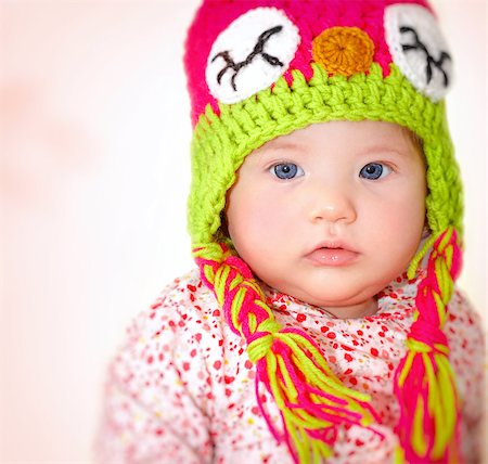 Closeup portrait of adorable child wearing beautiful colorful hat over pink background, cool winter style for little girls Stock Photo - Budget Royalty-Free & Subscription, Code: 400-08301993