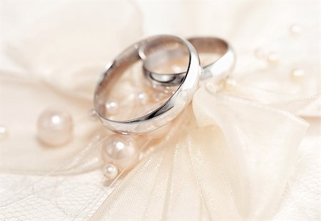 simsearch:670-06450369,k - Pair of golden wedding rings over invitation card decorated with silk bow & pearls Photographie de stock - Aubaine LD & Abonnement, Code: 400-08302032