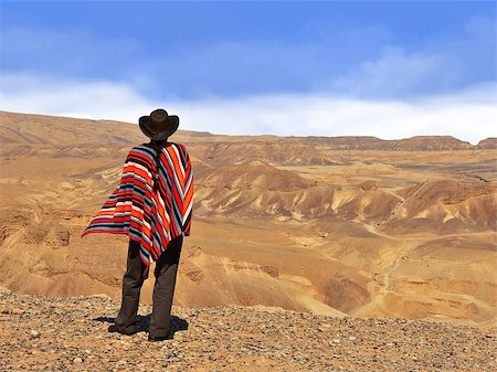 Men in a poncho in the desert. Blue sky and yellow desert. Stockbilder - Microstock & Abonnement, Bildnummer: 400-08314068