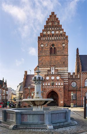 red town hall - Town hal in Roskilde is 19th century building in Neo-gothic style. The Gothic tower, the only remain of the St. Lawrence church, built in the early 12th century and destroyed during the Reformation. Stock Photo - Budget Royalty-Free & Subscription, Code: 400-08315255