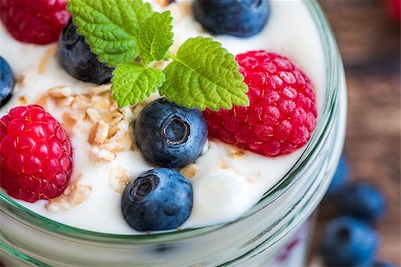 Serving of Yogurt with Whole Fresh Blueberries, Raspberries and Oatmeal on Old Rustic Wooden Table. Closeup Detail. Stock Photo - Budget Royalty-Free & Subscription, Code: 400-08315358