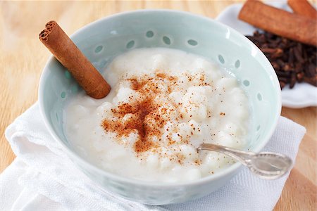 porage - Brazilian dessert canjica of white corn with cinnamon and clove in blue bowl. Selective focus Stock Photo - Budget Royalty-Free & Subscription, Code: 400-08315744