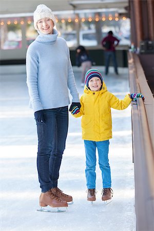 simsearch:400-08318057,k - young mother teaching her positive son ice skating, enjoying winter time at outdoor skating rink together Stock Photo - Budget Royalty-Free & Subscription, Code: 400-08315868