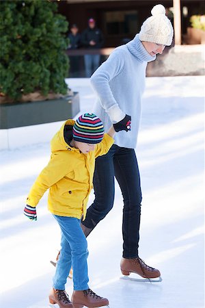 simsearch:400-08318057,k - young mother teaching her positive son ice skating, enjoying winter time at outdoor skating rink together Stock Photo - Budget Royalty-Free & Subscription, Code: 400-08315869