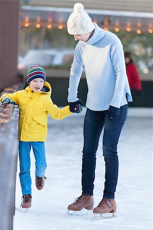 simsearch:400-08318063,k - young mother teaching her positive son ice skating, enjoying winter time at outdoor skating rink together Photographie de stock - Aubaine LD & Abonnement, Code: 400-08315872