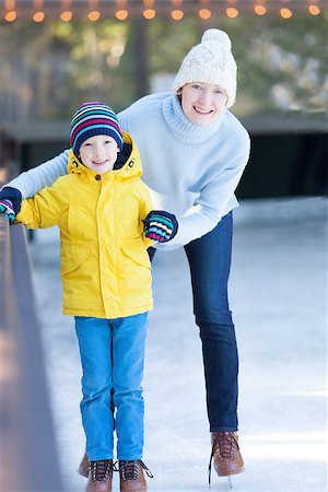 simsearch:400-08318057,k - young mother teaching her positive son ice skating, enjoying winter time at outdoor skating rink together Stock Photo - Budget Royalty-Free & Subscription, Code: 400-08315873