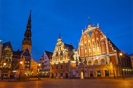 Famous House of Blackheads on the Town Square in Riga with a Church of St. Peter in the back. Latvia, after sunset.  House of Blackheads, destroyed during 2 World War, was reconstructed in the 1999. Foto de stock - Super Valor sin royalties y Suscripción, Código: 400-08315989