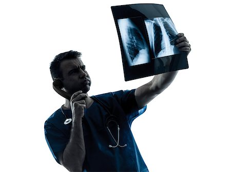 doctor examining confused - one  man doctor surgeon radiologist medical examining lung torso x-ray image silhouette isolated on white background Stock Photo - Budget Royalty-Free & Subscription, Code: 400-08316874
