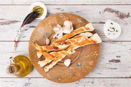 pan de ajo - Pizza breadsticks on white wooden background with olive oil and garlic basil dip. Culinary pizza eating. Foto de stock - Super Valor sin royalties y Suscripción, Código: 400-08317955