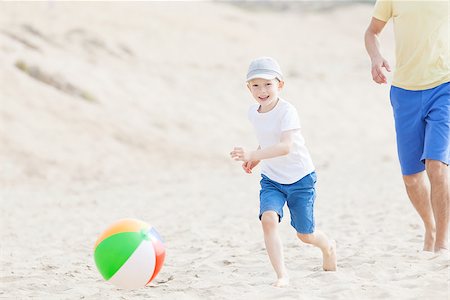 cheerful smiling son and his young father playing beach ball at the beach in california Stock Photo - Budget Royalty-Free & Subscription, Code: 400-08319482