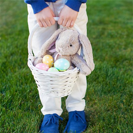 easter humour - little boy holding basket with colorful easter eggs and bunny in the park enjoying spring time, no face visible Stock Photo - Budget Royalty-Free & Subscription, Code: 400-08319513