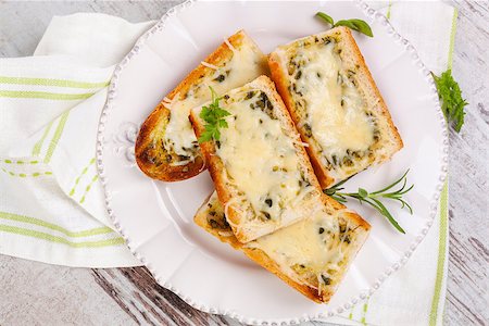 Baguette with melted cheese and fresh herbs on white wooden background, top view. Culinary eating. Stock Photo - Budget Royalty-Free & Subscription, Code: 400-08319930