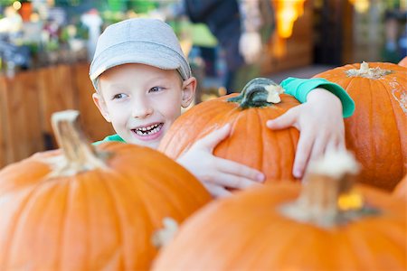 simsearch:400-07169847,k - cheerful little boy holding pumpkin enjoying halloween time at pumpkin patch Photographie de stock - Aubaine LD & Abonnement, Code: 400-08320117