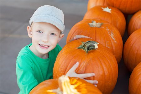 simsearch:400-07169847,k - cheerful little boy holding pumpkin enjoying halloween time at pumpkin patch Photographie de stock - Aubaine LD & Abonnement, Code: 400-08320118