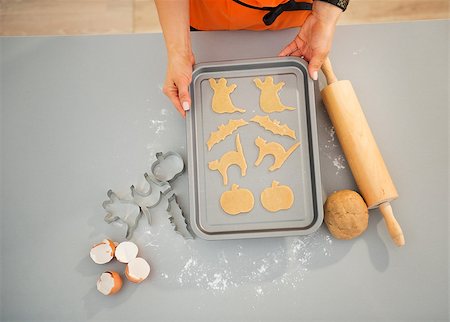 rolling over - Closeup on housewife with tray of uncooked Halloween biscuits. Halloween treats ready to go into oven. Upper view Stock Photo - Budget Royalty-Free & Subscription, Code: 400-08336567