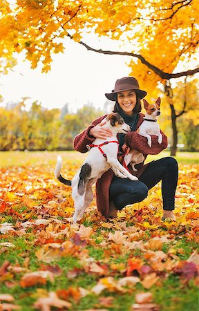 Young woman in brown hat with two little dogs playing outside in autumn leaves Stock Photo - Budget Royalty-Free & Subscription, Code: 400-08337664