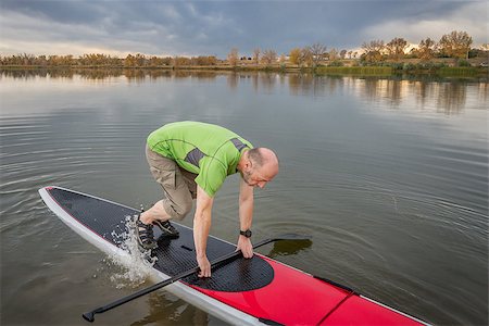 simsearch:400-07795226,k - senior male is starting  paddling workout on his stand up paddleboard on a lake in Colorado Foto de stock - Royalty-Free Super Valor e Assinatura, Número: 400-08338013