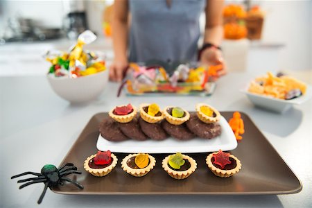 Closeup on horribly tasty delicious halloween treats on table in kitchen and woman in background. Ready to halloween party. Traditional autumn holiday Stock Photo - Budget Royalty-Free & Subscription, Code: 400-08338077