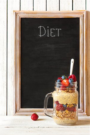 simsearch:400-06761866,k - Healthy diet breakfast. Homemade granola, chia seeds yogurt and fresh berries in mason jar with chakl blackboard for text. Photographie de stock - Aubaine LD & Abonnement, Code: 400-08338418