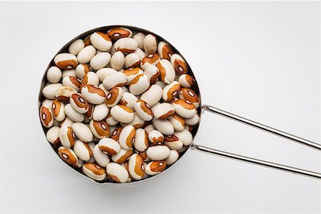 simsearch:400-08342479,k - Metal measuring cup of yellow eye beans related to the kidney bean. This bean is also referred to as a Dot-Eye Bean, Molasses-Face Bean and Yellow-Eyed China Bean. Stock Photo - Budget Royalty-Free & Subscription, Code: 400-08338724