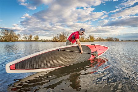 simsearch:400-07795226,k - senior male launching  his 14 feet long expedition stand up paddleboard on a lake in Colorado, fall scenery Foto de stock - Royalty-Free Super Valor e Assinatura, Número: 400-08338722
