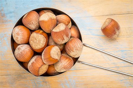 simsearch:400-08342479,k - metal measuring scoop of hazelnuts (in shells) against grunge wood table Stock Photo - Budget Royalty-Free & Subscription, Code: 400-08339446