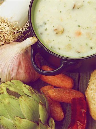 simsearch:400-07625359,k - Healthy Artichoke Creamy Soup with Leek, Carrot, Garlic and Cheese in Dark Blue Pannikin closeup on Rustic Wooden background. Retro Styled Photographie de stock - Aubaine LD & Abonnement, Code: 400-08339764