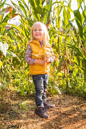 Portrait of cute smiling child staying in the corn field on farm on sunny autumn day Stock Photo - Budget Royalty-Free & Subscription, Code: 400-08339785