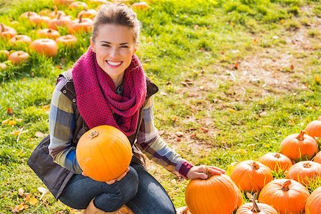 simsearch:400-07916492,k - Portrait of smiling beautiful woman holding pumpkins on the pumpkin patch on farm during the autumn season Stock Photo - Budget Royalty-Free & Subscription, Code: 400-08339783