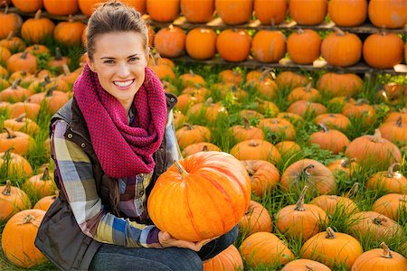 simsearch:400-07916492,k - Portrait of smiling woman sitting and holding big pumpkin on farm during the autumn season Stock Photo - Budget Royalty-Free & Subscription, Code: 400-08339796