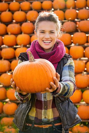 simsearch:400-07916492,k - Portrait of smiling young woman holding big pumpkin on farm during the autumn season Stock Photo - Budget Royalty-Free & Subscription, Code: 400-08339792