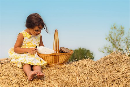 Little girl sitting on haystack with a basket of healthy food (Annapolis Valley, Nova Scotia, Canada) Stockbilder - Microstock & Abonnement, Bildnummer: 400-08333330