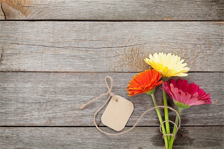 simsearch:400-07662543,k - Three colorful gerbera flowers with tag on wooden table Stock Photo - Budget Royalty-Free & Subscription, Code: 400-08344226