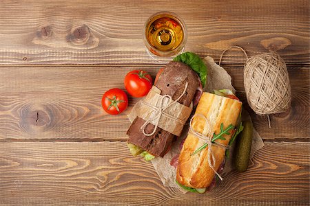 Two sandwiches and white wine glass on wooden table. Top view with copy space Stock Photo - Budget Royalty-Free & Subscription, Code: 400-08344221