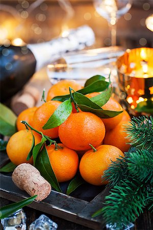 Holiday concept: fresh tangerines, cork, glass, champagne, candles and garlands Stock Photo - Budget Royalty-Free & Subscription, Code: 400-08344408