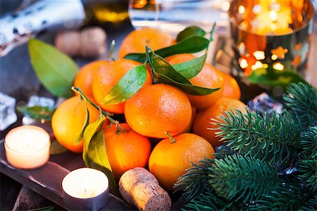 Holiday concept: fresh tangerines, cork, glass, champagne, candles and garlands Stock Photo - Budget Royalty-Free & Subscription, Code: 400-08344409