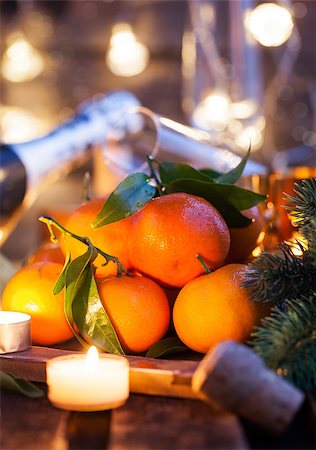 Holiday concept: fresh tangerines, cork, glass, champagne, candles and garlands Stock Photo - Budget Royalty-Free & Subscription, Code: 400-08344410