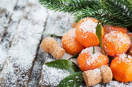 Fresh tangerines with leaves on a snow-covered table with a branch of spruce Stockbilder - Microstock & Abonnement, Bildnummer: 400-08344413