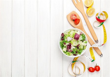 simsearch:400-06485512,k - Fresh healthy salad, utensils and tape measure over white wooden table. View from above with copy space Stock Photo - Budget Royalty-Free & Subscription, Code: 400-08346952