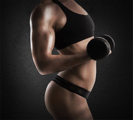 simsearch:400-08505882,k - Muscular woman is training with a dumbbell Stock Photo - Budget Royalty-Free & Subscription, Code: 400-08340638