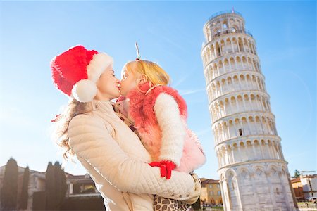 simsearch:400-08341864,k - Mother in Christmas hat and daughter wearing funny reindeer antlers kissing in front of Leaning Tour of Pisa, Italy. They spending exciting Christmas time traveling. Fotografie stock - Microstock e Abbonamento, Codice: 400-08340899