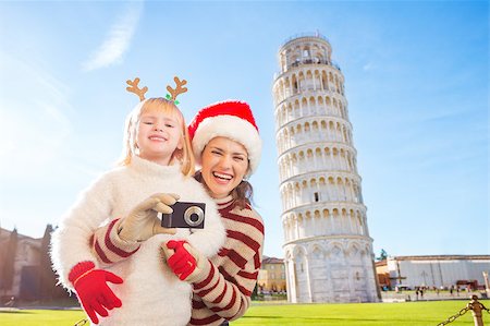 simsearch:400-08341864,k - Happy mother in Christmas hat and daughter wearing funny reindeer antlers taking photos in front of Leaning Tour of Pisa, Italy. They spending exciting Christmas time traveling. Fotografie stock - Microstock e Abbonamento, Codice: 400-08340916