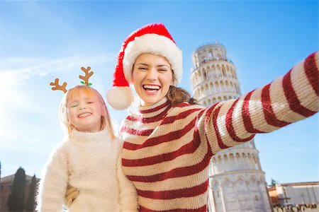 simsearch:400-08341864,k - Happy mother in Christmas hat taking selfie with daughter wearing funny reindeer antlers while standing in front of Leaning Tour of Pisa, Italy. They spending exciting Christmas time traveling Fotografie stock - Microstock e Abbonamento, Codice: 400-08340920