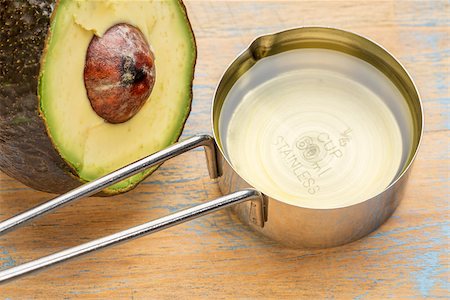 simsearch:400-08342479,k - avocado  oil in a metal measuring cup against painted wood with a half of avacado fruit Stock Photo - Budget Royalty-Free & Subscription, Code: 400-08340951