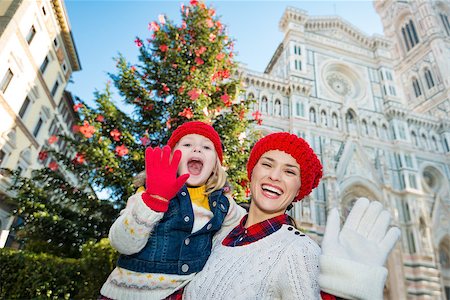 simsearch:400-08341864,k - Portrait of smiling mother and daughter handwaving in front of Christmas tree near Duomo in Florence, Italy. Modern family enjoying carousel of Christmas time events in heart of the Renaissance. Fotografie stock - Microstock e Abbonamento, Codice: 400-08341868