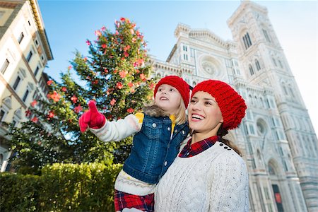 simsearch:400-08341864,k - Excited mother and daughter pointing on something while standing near Christmas tree and Duomo in Florence, Italy. Modern family enjoying carousel of Christmas time events in heart of the Renaissance. Fotografie stock - Microstock e Abbonamento, Codice: 400-08341863