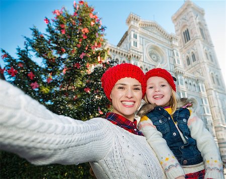 simsearch:400-08341864,k - Happy mother and daughter taking selfie in front of Christmas tree near Duomo in Florence, Italy. Modern family enjoying carousel of Christmas time events in heart of the Renaissance. Fotografie stock - Microstock e Abbonamento, Codice: 400-08341877