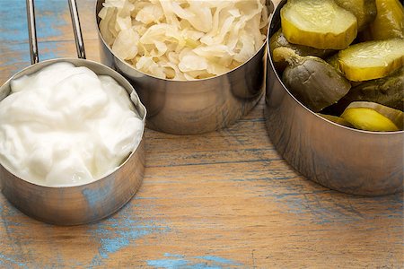 simsearch:400-08342479,k - sauerkraut, cucumber pickles and yogurt - popular probiotic fermented food - three measuring cups against rustic wood Stock Photo - Budget Royalty-Free & Subscription, Code: 400-08342481