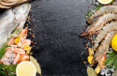 poisson tigre - Fresh raw sea food with spices on black stone background. Top view with copy space Photographie de stock - Aubaine LD & Abonnement, Code: 400-08343144