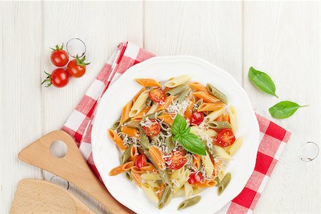 Colorful penne pasta with tomatoes and basil on wooden table. Top view Stock Photo - Budget Royalty-Free & Subscription, Code: 400-08343179